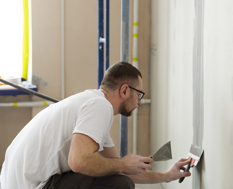 full-shot-worker-using-plastering-trowel